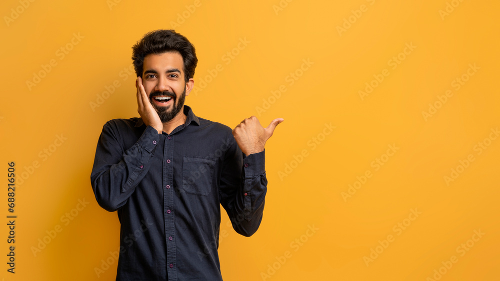Amazing Offer. Excited Indian Guy Touching Face And Pointing At Copy Space Amazing Offer. Excited Indian Guy Touching Face And Pointing At Copy Space