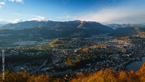 Wide-angle sunset view from the summit of Monte San Salvatore overlooking Lake Lugano Breathtaking panorama of the city, Melide causeway and the Swiss Alps in Ticino, Switzerland - November 2023