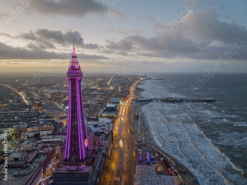 Blackpool, Lancashire, United Kingdom. Blackpool sea front and tower aerial view at dusk looking towards the pier and pleasure beach on the Lancashire coast.  photo