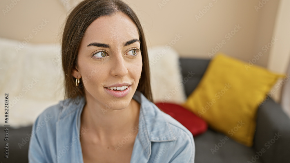 Heartwarming portrait of a young, beautiful hispanic woman, exuding confidence and joy, relaxing on her sofa at home, smiling off to the side Heartwarming portrait of a young, beautiful hispanic woman, exuding confidence and joy, relaxing on her sofa at home, smiling off to the side