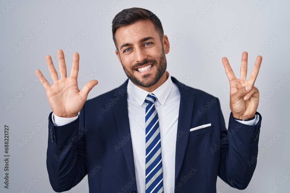 Handsome hispanic man wearing suit and tie showing and pointing up with fingers number eight while smiling confident and happy. Handsome hispanic man wearing suit and tie showing and pointing up with fingers number eight while smiling confident and happy.
