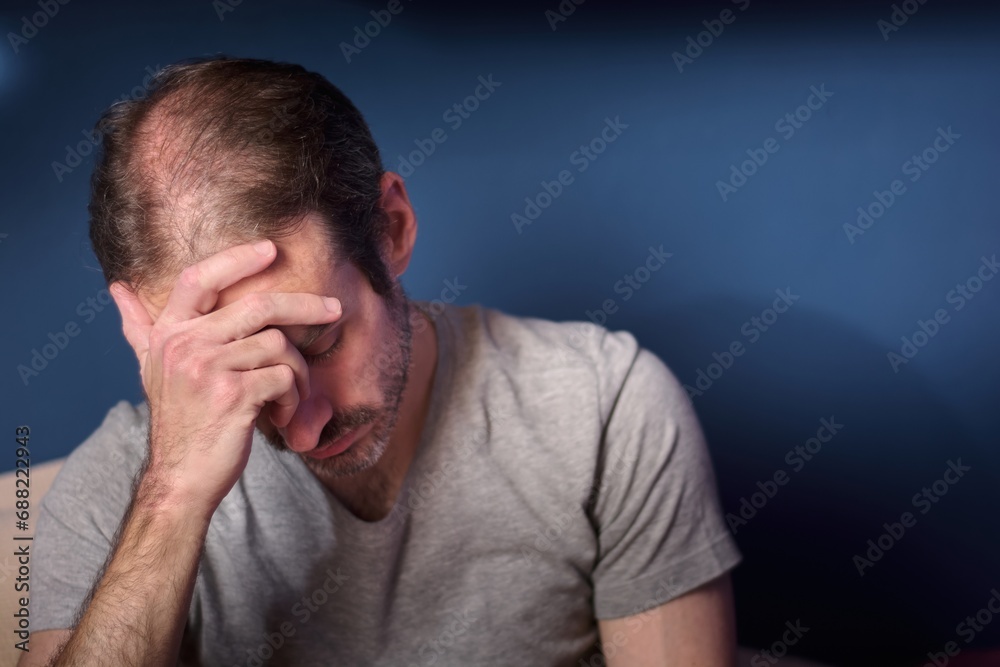 Young caucasian 30 year old man with short beard holding his head. Concept of depression, loss and grief. Adult person expressing stress and anxiety. Emotional trauma Young caucasian 30 year old man with short beard holding his head. Concept of depression, loss and grief. Adult person expressing stress and anxiety. Emotional trauma