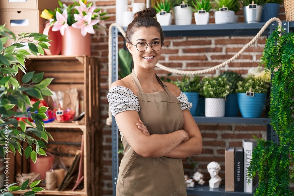 Young beautiful hispanic woman florist smiling confident standing with arms crossed gesture at florist