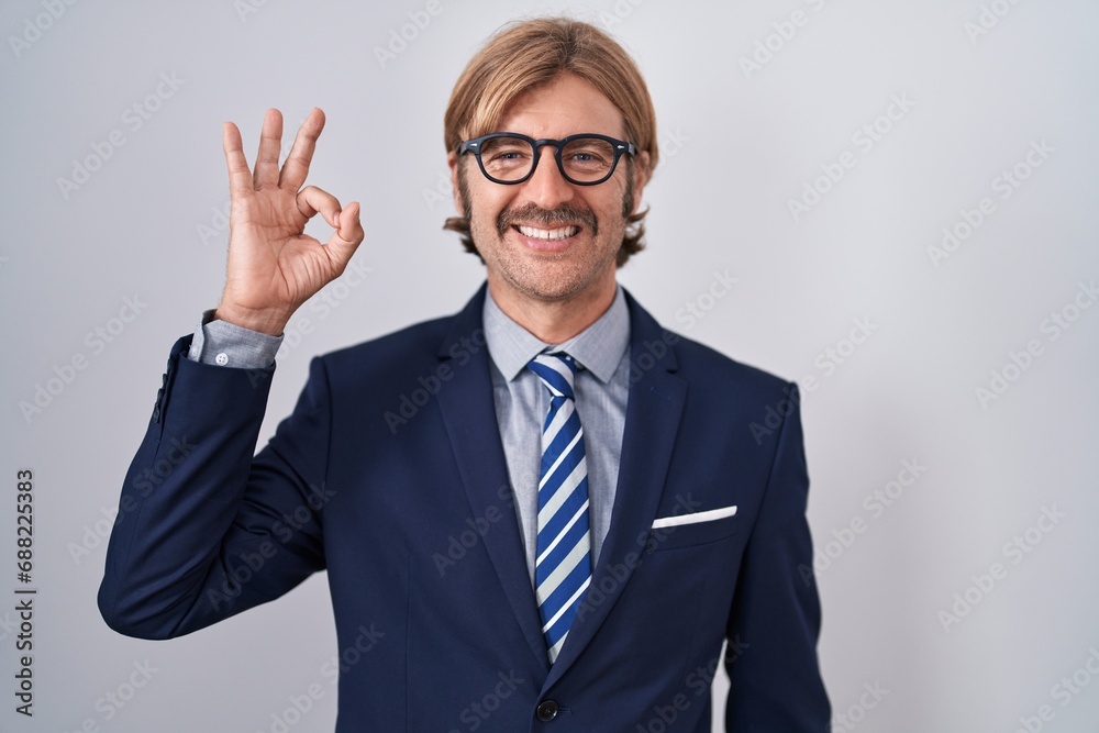 Caucasian man with mustache wearing business clothes smiling positive doing ok sign with hand and fingers. successful expression.