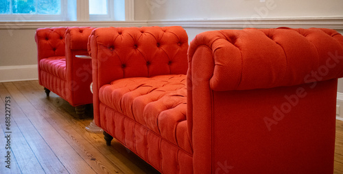 Tufted orange settee couches in a reception office setting
