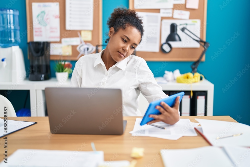 African american woman business worker using laptop and touchpad at office African american woman business worker using laptop and touchpad at office