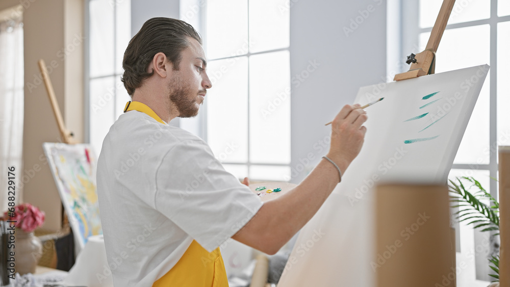 Young hispanic man artist drawing concentrated at art studio Young hispanic man artist drawing concentrated at art studio