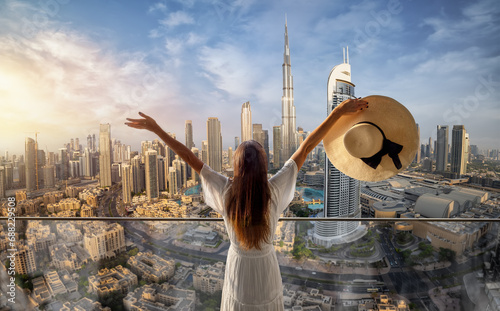 Photography A elegant woman in a white dress  looks at the panoramic sunset view of the down