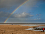 Nature scene with beach, ocean and cloudy sky with rainbow. Rich saturated colors. Nature wonder scene. West of Ireland.