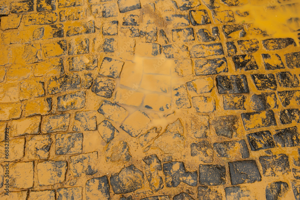 Detail of a stretch of street paved with cobblestones, soiled with mud by flooding from the Pomba River, in the city of Guarani, in the Zona da Mata of the state of Minas Gerais, Brazil.