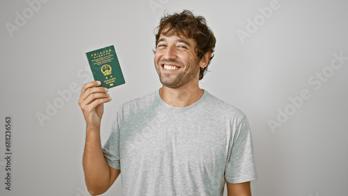 Beaming young man ecstatically waving his macao passport, soaking up happiness on stark white backdrop! photo