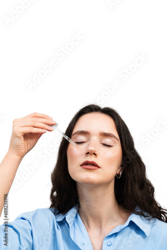 Girl is dropping hyaluronic acid or serum from pipette on face close-up. Young woman is applying moisturizing serum on her face.