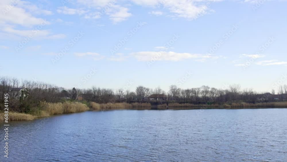 Rippling surface of a lake under blue cloudy sky in Zrenjanin, Serbia Rippling surface of a lake under blue cloudy sky in Zrenjanin, Serbia