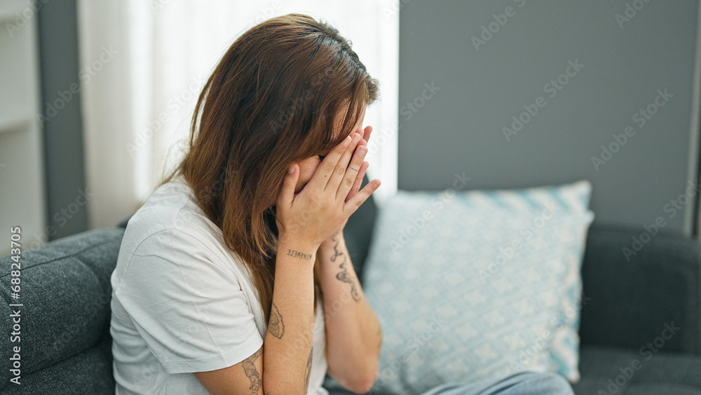 Young beautiful hispanic woman sitting on the sofa crying at home Young beautiful hispanic woman sitting on the sofa crying at home