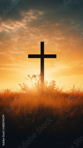 Silhouette Christian cross on grass in sunrise background © David