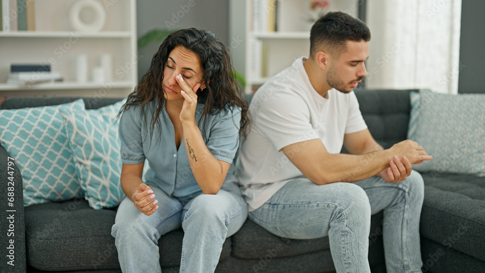 Man and woman couple sitting on sofa arguing stressed at home Man and woman couple sitting on sofa arguing stressed at home