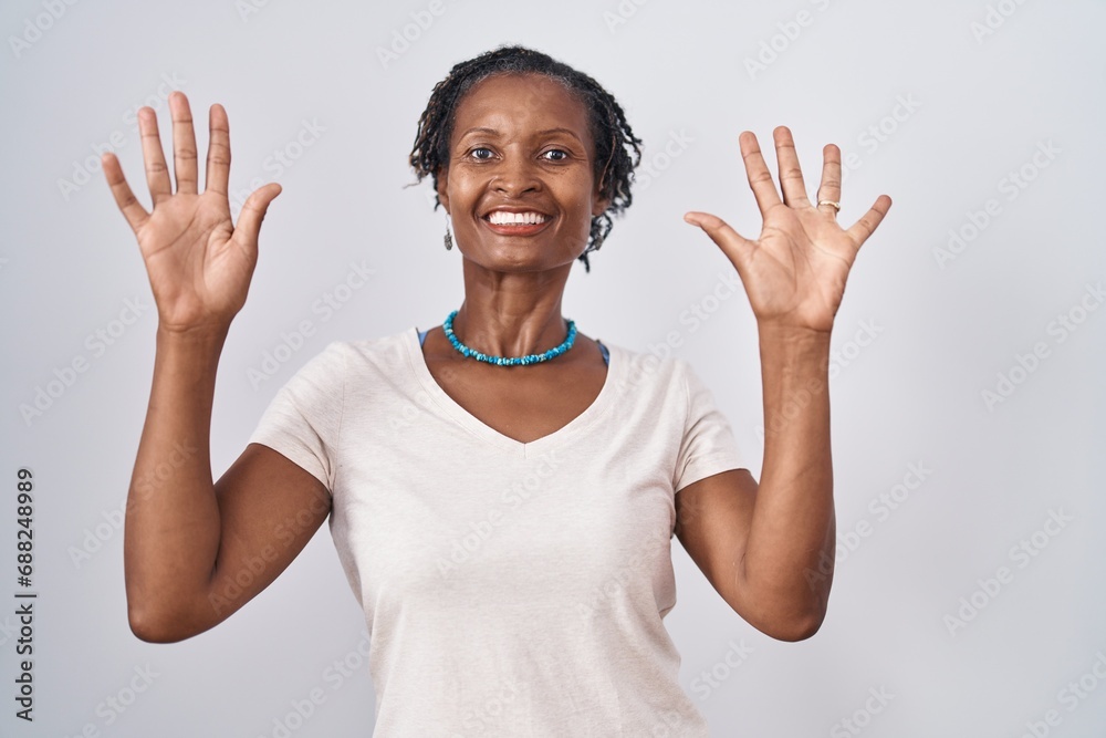 African woman with dreadlocks standing over white background showing and pointing up with fingers number ten while smiling confident and happy. African woman with dreadlocks standing over white background showing and pointing up with fingers number ten while smiling confident and happy.