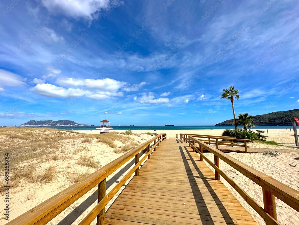 beautiful beach access to the Playa de Getares with palms near Algeciras on the Bay of Gibraltar with a view towards Gibraltar, Andalusia, Spain