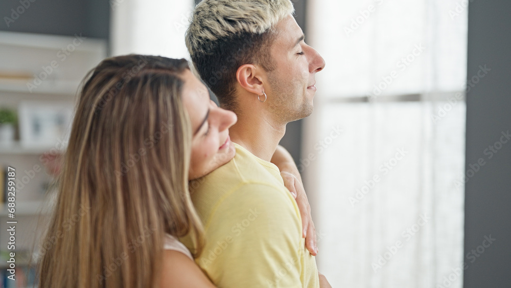 Beautiful couple smiling confident hugging each other at home