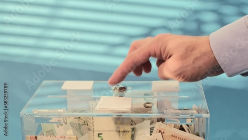 Hand give Charity in nominal 5 Euro banknotes to a transparent donation box for money donation. A financial support, collects money for a noble cause. The 