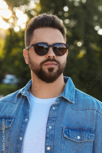 Handsome man in sunglasses outdoors on summer day