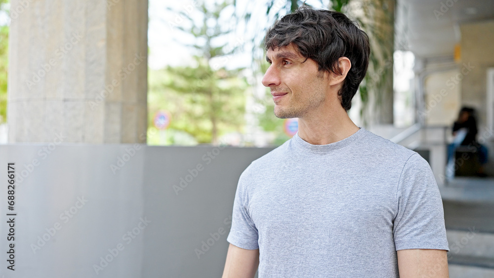 Young hispanic man looking to the side with serious expression at street Young hispanic man looking to the side with serious expression at street