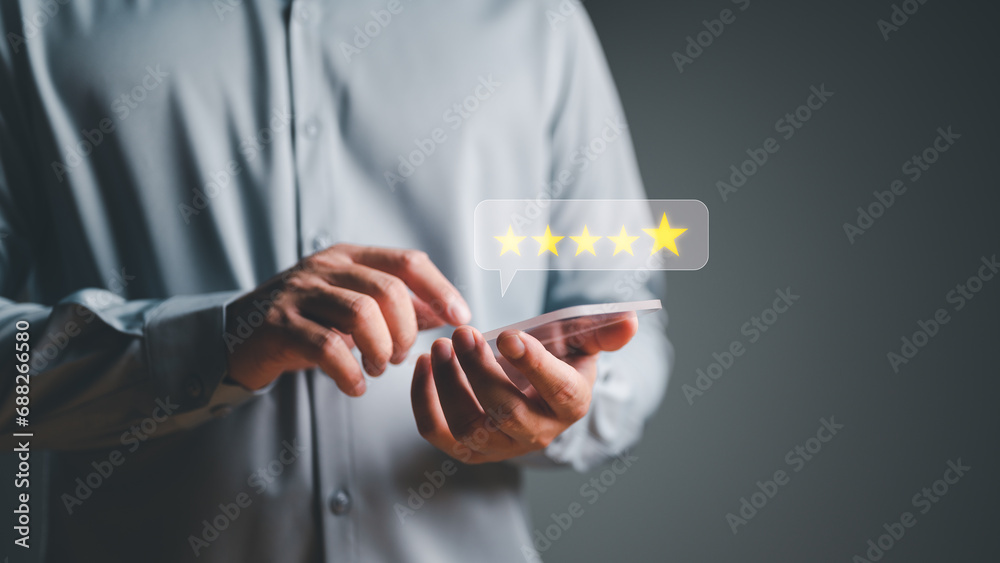 Close up on customer hand pressing on smartphone with gold five-star rating feedback icon and press level excellent rank for giving best score point to review the product and service, business concept