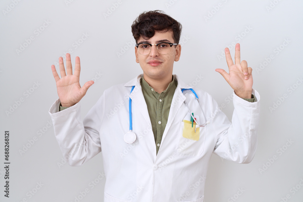 Young non binary man wearing doctor uniform and stethoscope showing and pointing up with fingers number eight while smiling confident and happy. Young non binary man wearing doctor uniform and stethoscope showing and pointing up with fingers number eight while smiling confident and happy.