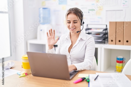 Young blonde woman wearing call center agent headset looking positive and happy standing and smiling with a confident smile showing teeth
