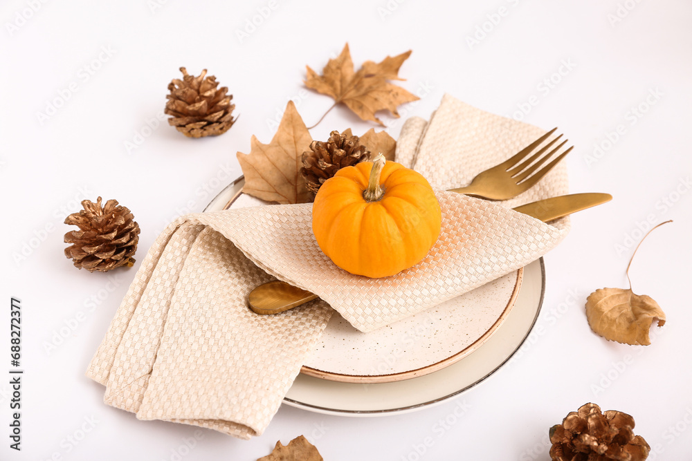 Autumn table setting with pumpkin, leaves and cones on white background