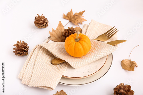 Autumn table setting with pumpkin  leaves and cones on white background