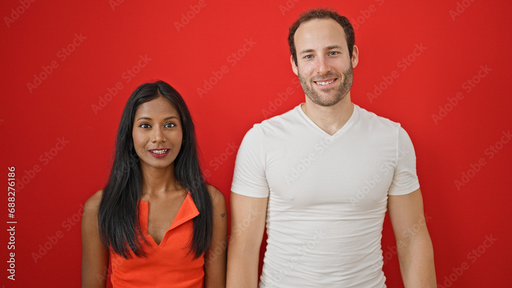 Beautiful couple smiling confident standing together over isolated red background Beautiful couple smiling confident standing together over isolated red background