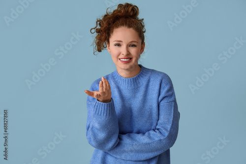 Portrait of confused young woman on blue background