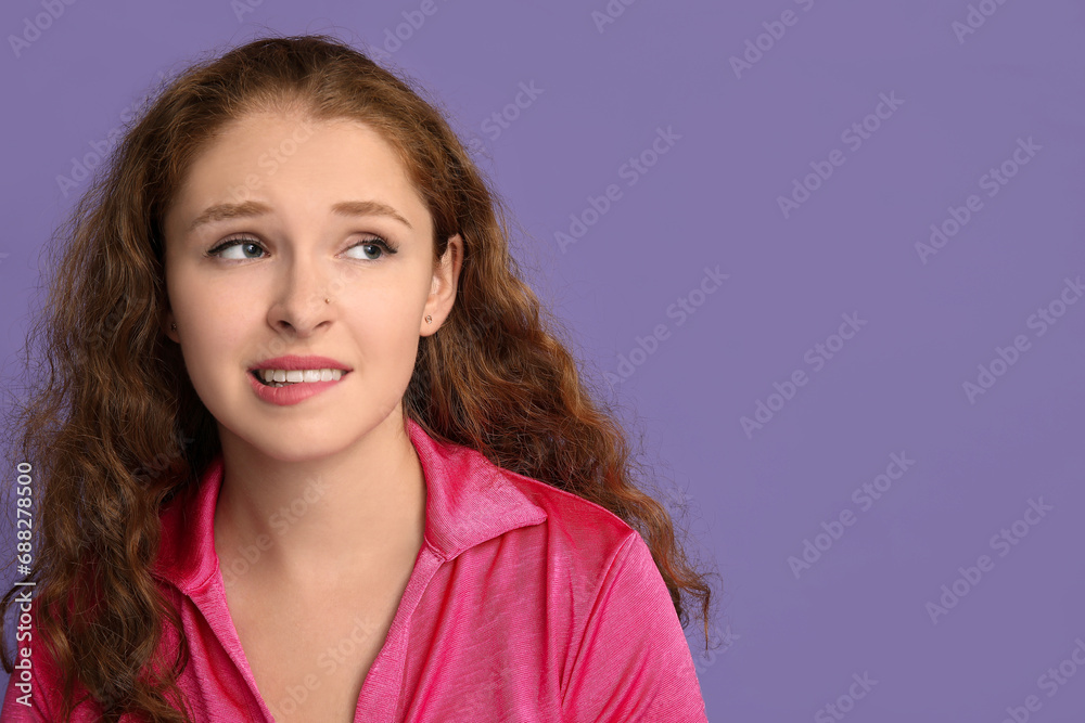 Fototapeta premium Portrait of nervous young woman on purple background