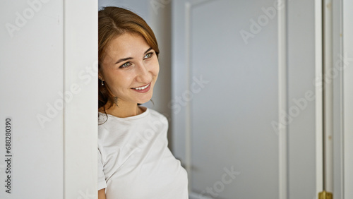 Young woman leaning on door smiling at home
