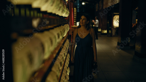 Photography Beautiful young hispanic woman looking at asian lantern at japanese temple in to