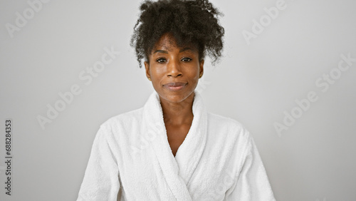 African american woman wearing bathrobe standing with serious face over isolated white background photo