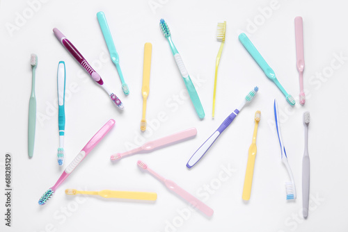 Colorful plastic toothbrushes on white background.