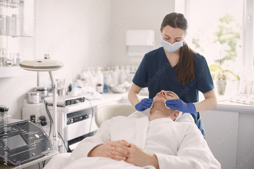 Obraz premium Man in cosmetologist cabinet has a skincare procedure