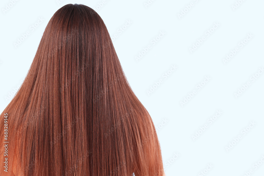 Young brunette woman with beautiful hair on blue background, back view Young brunette woman with beautiful hair on blue background, back view