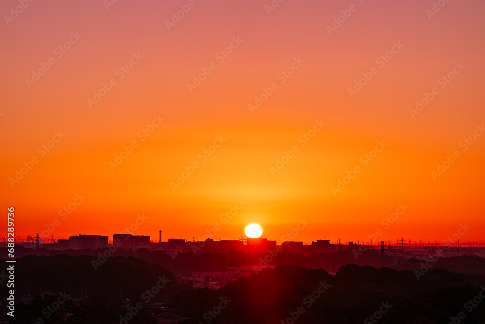 日の出の太陽と郊外の地平線