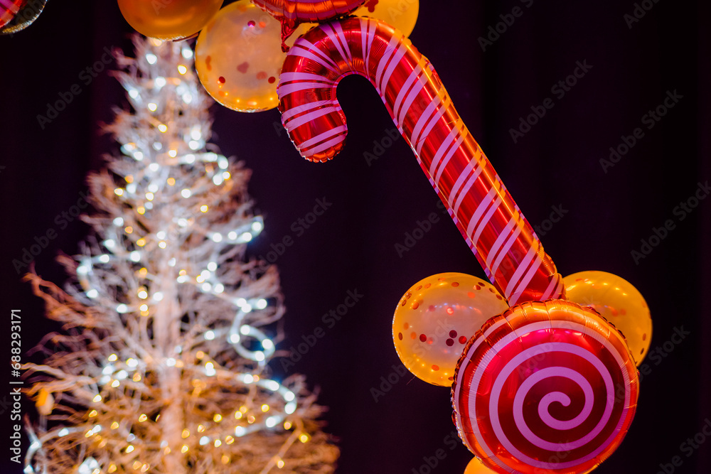 Christmas decorations such as giant nutcracker dolls, balloons of different shapes such as candy, stars and classic balloons, in the background a Christmas tree.