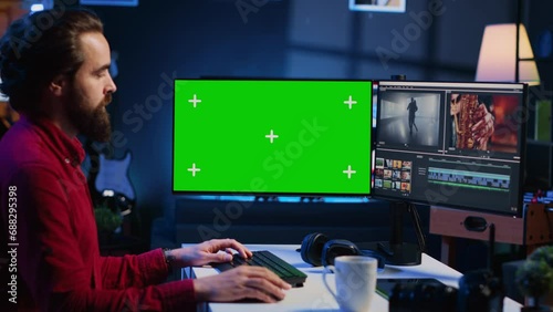 Videographer uses editing software on green screen computer to assemble footage into cohesive final result. Expert color correcting clips on mockup monitor to ensure project meets desired aesthetic photo
