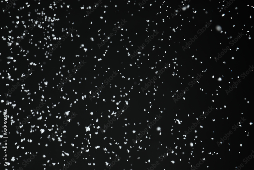 White snow falling down on black background White snow falling down on black background