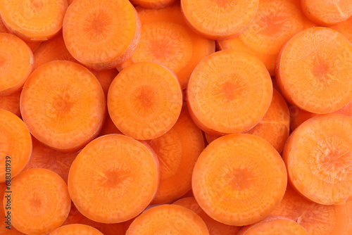Slices of fresh ripe carrot as background, top view