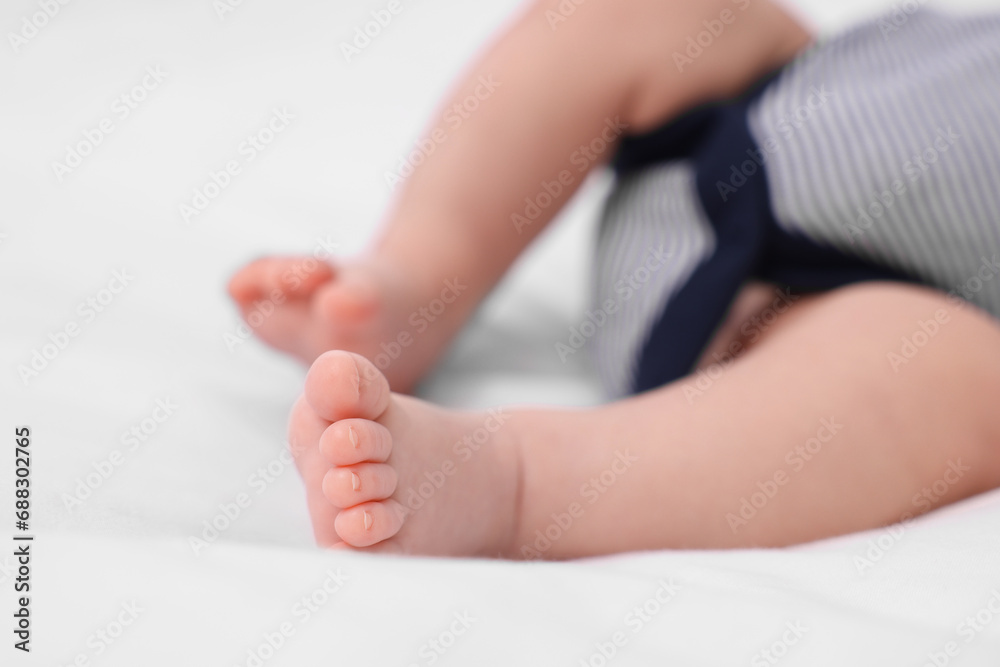 Newborn baby lying on white blanket, closeup