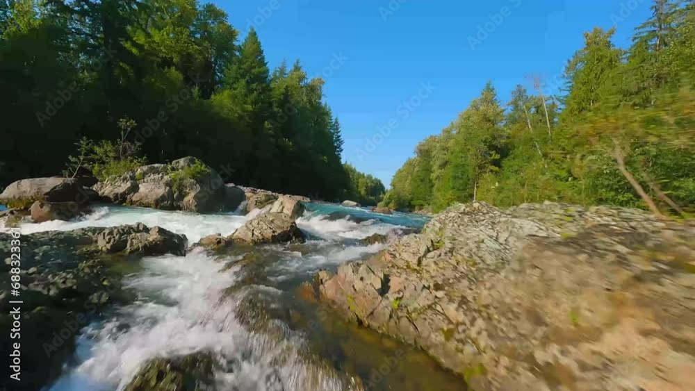 FPV drone flight over the fast moving river with rapids, close to the water. FPV drone flight over the fast moving river with rapids, close to the water.