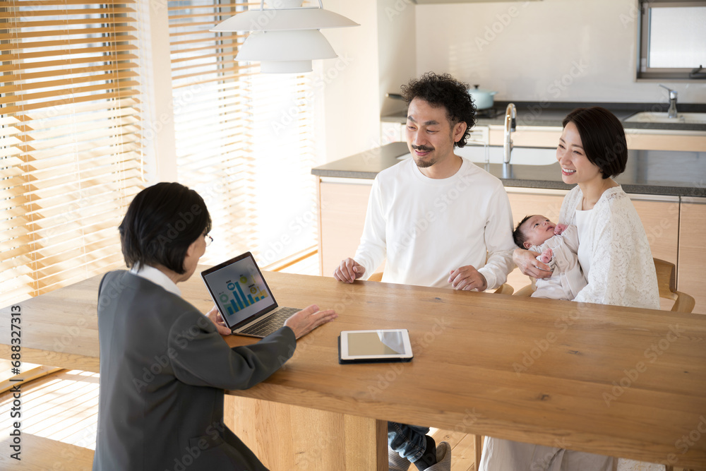 A woman selling insurance and other services and a family (couple) with a baby A woman selling insurance and other services and a family (couple) with a baby