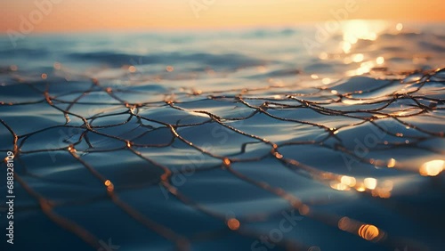 Closeup of a long, thin mesh net dd over the surface of the water, designed to skim and collect oil from the oceans surface. photo