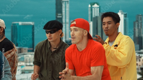 Closeup of street dancer wear colorful outfit while dance together. Group of attractive hipster dance and move to hip-hop music at skyscraper and city view. Break dance. Outdoor sport 2024. Endeavor.